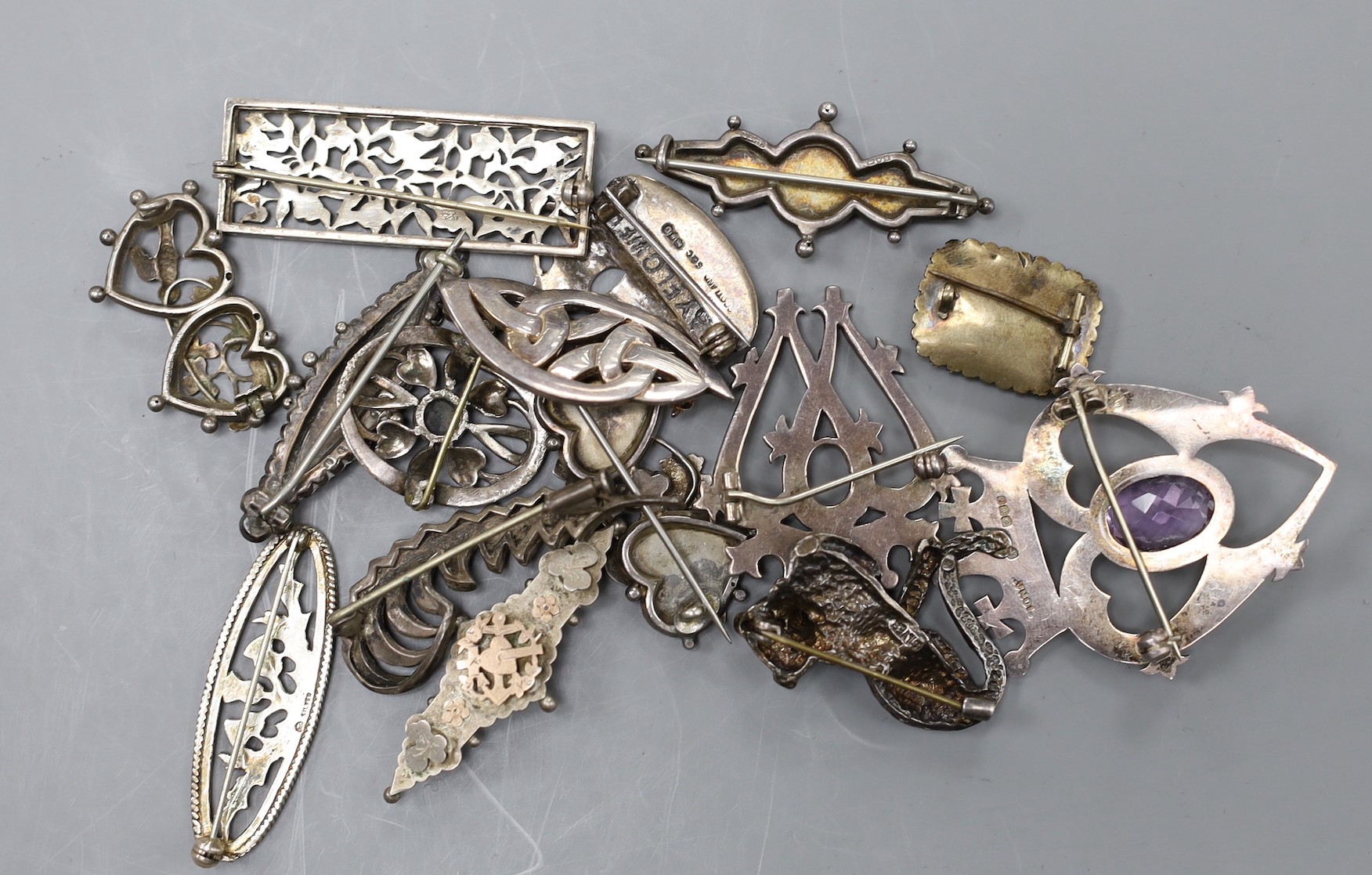 Eight assorted Victorian and later silver brooches, including part yellow metal and one heart shape set with amethyst, 52mm, together with seven other brooches including white metal and a mourning brooch.